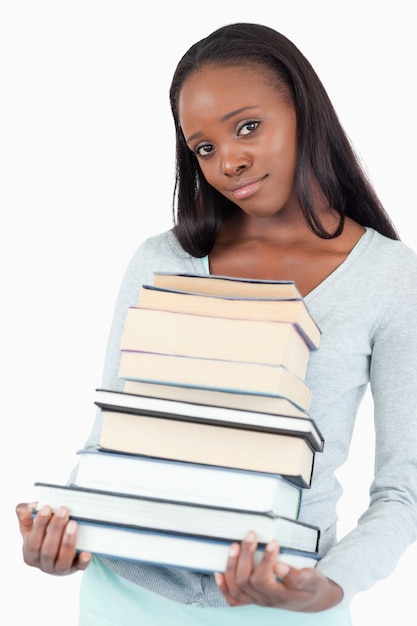 Triste donna sorridente con una pila di libri