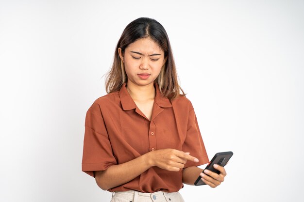 Triste giovane donna asiatica durante l'utilizzo del telefono cellulare
