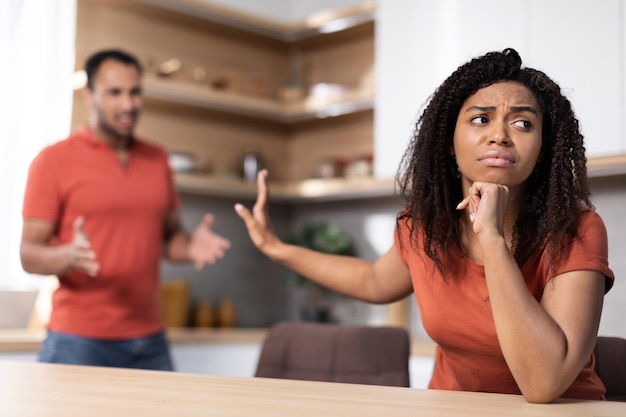 Triste ragazzo nero millenario giura alla moglie che la donna ignora la lite all'interno della cucina