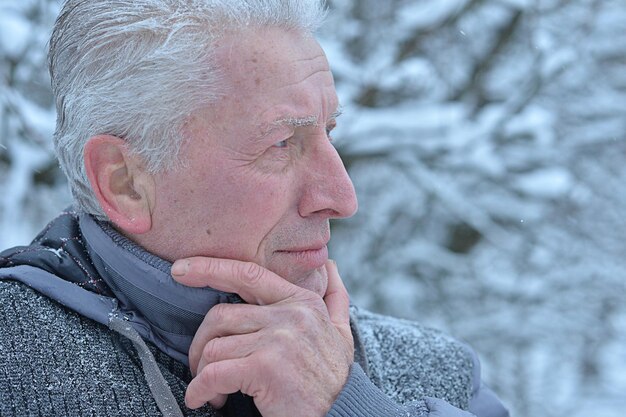 Triste uomo anziano in piedi all'aperto in inverno