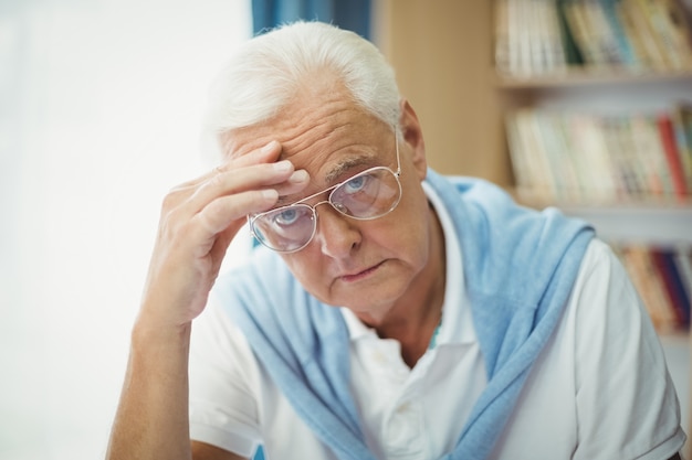 Triste uomo anziano seduto al tavolo