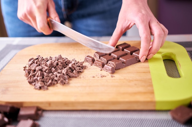 Tritare una tavoletta di cioccolato mentre si prepara il budino al cioccolato o la cottura al forno