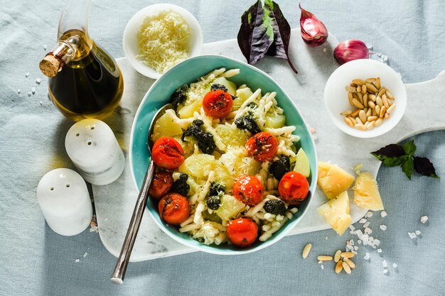 Trofie di pasta italiana con patate pomodorini fritti e pesto di basilico sana cucina tradizionale