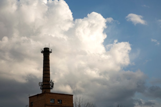 Tromba di un vecchio locale caldaia contro un cielo azzurro con nuvole bianche Ecologia dell'inquinamento ambientale