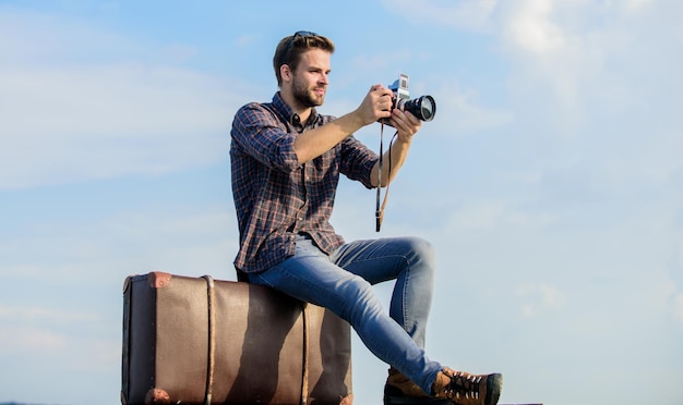 Trova il tuo viaggiatore di fuga aspetta l'auto moda maschile stile cercando fotografo alla moda con gli occhiali uomo macho con fotocamera sul bagaglio cattura giornalista avventura uomo sexy reporter turistico