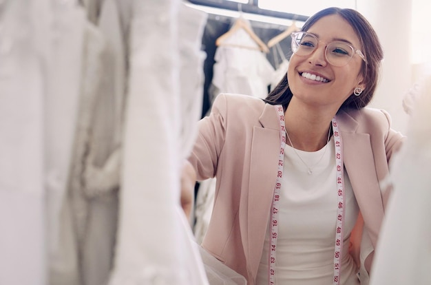 Troverai sicuramente qualcosa che ti piace nel mio negozio. Foto di una giovane sarta attraente che lavora in una boutique da sposa