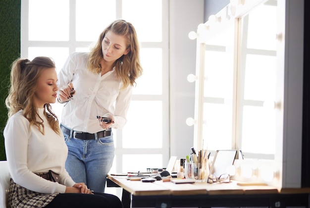 Truccatore che fa trucco professionale della giovane donna