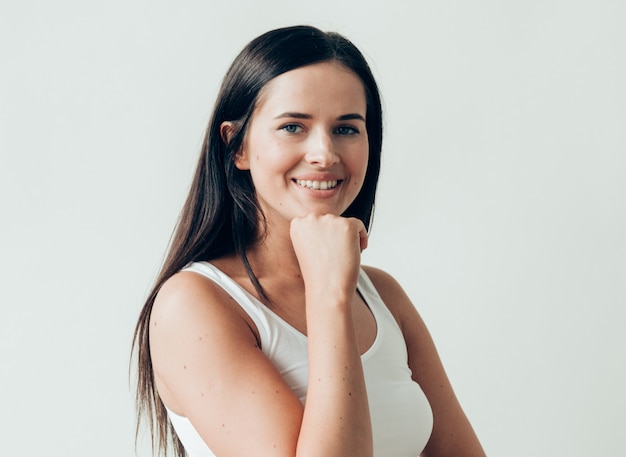 Trucco casuale dei capelli lunghi della donna castana naturale. Colpo dello studio.