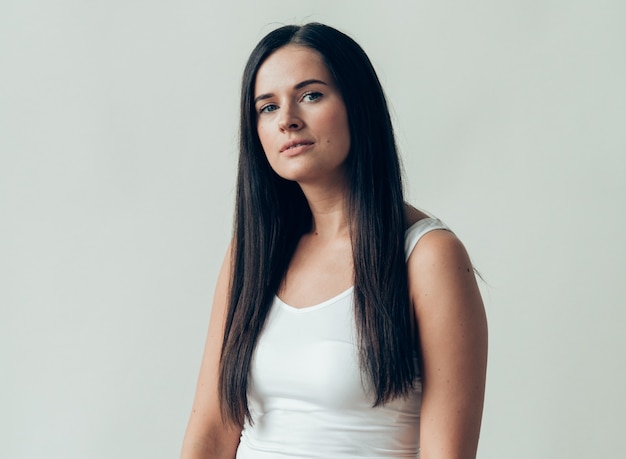 Trucco casuale dei capelli lunghi della donna castana naturale. Colpo dello studio.