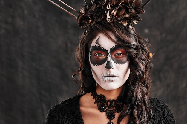 Trucco cerimoniale per l'occasione Ritratto ritagliato di una giovane donna attraente vestita con il suo costume di Halloween in stile messicano