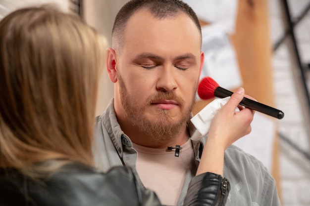 Trucco dell'attore uomo prima delle riprese da vicino