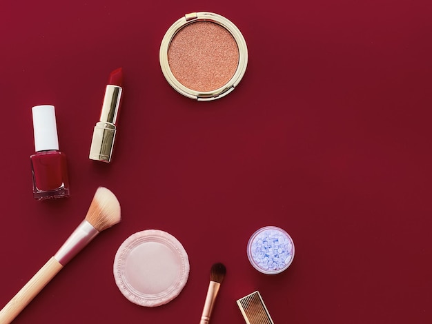 Trucco di bellezza e cosmetici flatlay design con prodotti cosmetici copyspace e strumenti per il trucco su sfondo bordeaux concetto di stile femminile e femminile