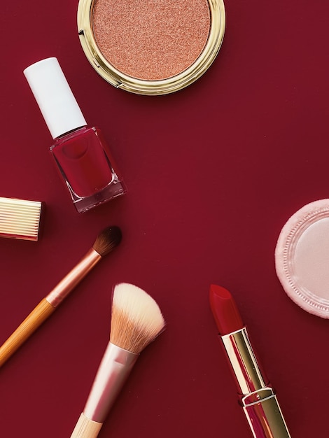 Trucco di bellezza e cosmetici flatlay design con prodotti cosmetici copyspace e strumenti per il trucco su sfondo bordeaux concetto di stile femminile e femminile