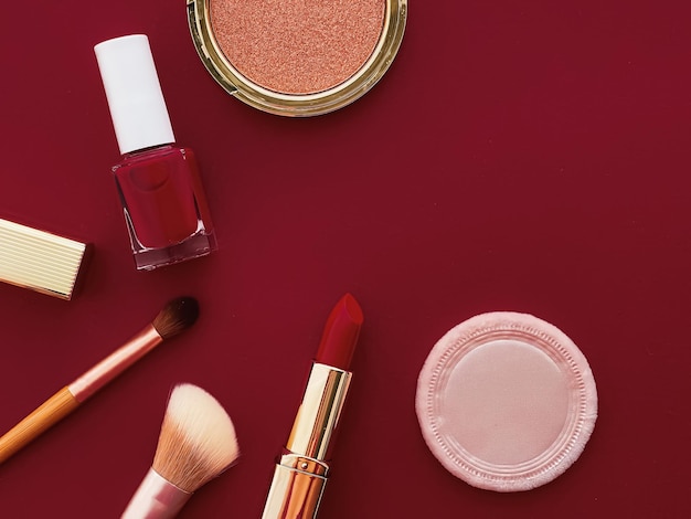 Trucco di bellezza e cosmetici flatlay design con prodotti cosmetici copyspace e strumenti per il trucco su sfondo bordeaux concetto di stile femminile e femminile