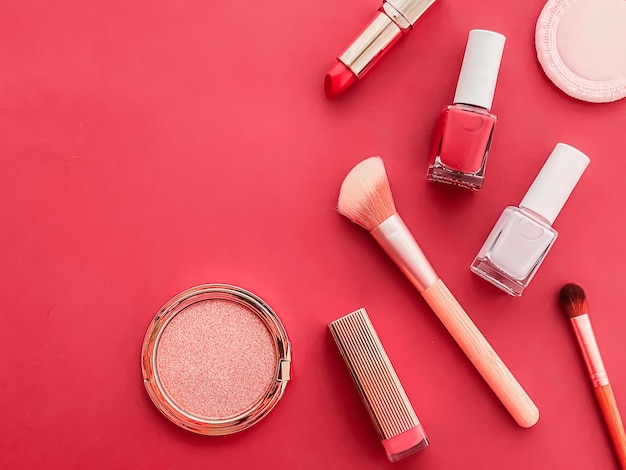 Trucco di bellezza e cosmetici flatlay design con prodotti cosmetici copyspace e strumenti per il trucco su sfondo corallo concetto di stile femminile e femminile