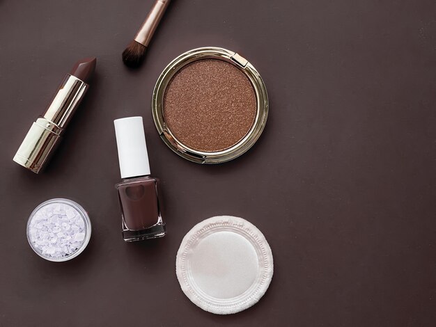 Trucco di bellezza e cosmetici flatlay design con prodotti cosmetici copyspace e strumenti per il trucco su sfondo marrone stile femminile e femminile