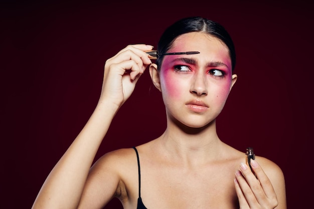 Trucco luminoso donna alla moda in posa di moda emozioni cosmetici sfondo rosa inalterato