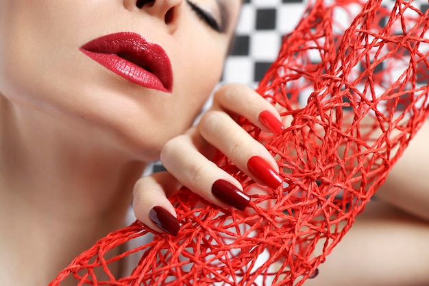 Trucco occhi creativo su una ragazza con rossetto rosso e manicure