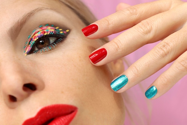 Trucco occhi creativo su una ragazza con rossetto rosso e manicure