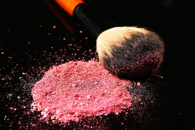 Trucco pennello e fard rosa su sfondo scuro