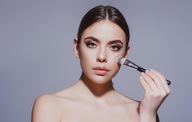 Trucco per la cura della pelle e cosmetici viso donna con trattamenti di bellezza con pennello per il trucco