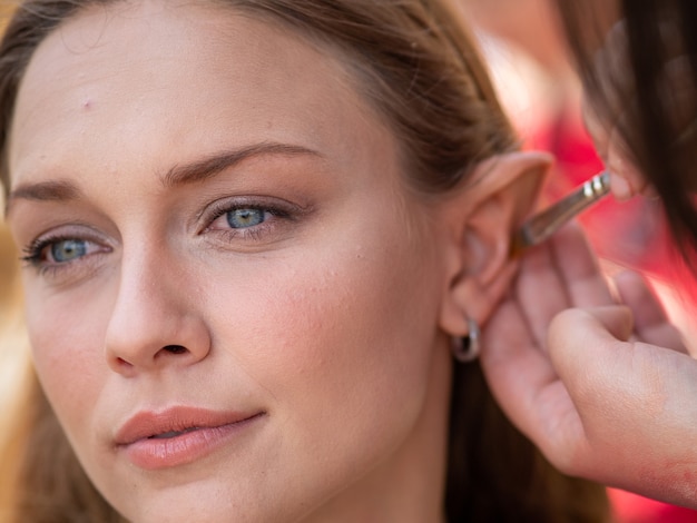 Trucco sulle orecchie a una modella per trasformarla in un elfo