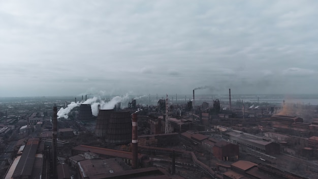 Tubi alti della centrale elettrica a carbone con fumo velenoso verde che sale l'atmosfera inquinante della città
