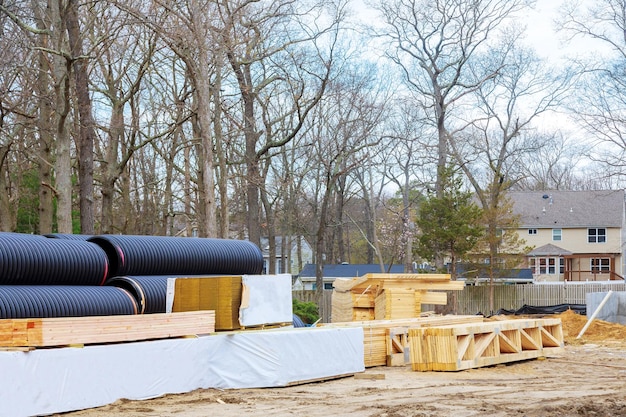 Tubi in PVC di plastica impilati su materiali da costruzione in legno impilati di tavole costruzione di travi a telaio in legno