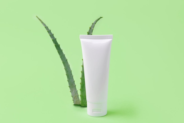 Tubo cosmetico vuoto con aloe vera su sfondoConcetto cosmetico organico