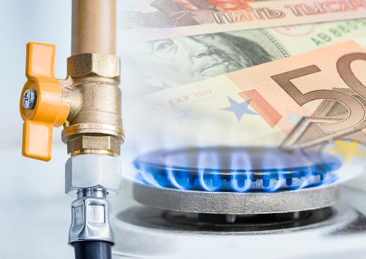 Tubo del gas con rubinetto giallo aperto che brucia bruciatore a gas e rublo del dollaro e banconote di carta in euro