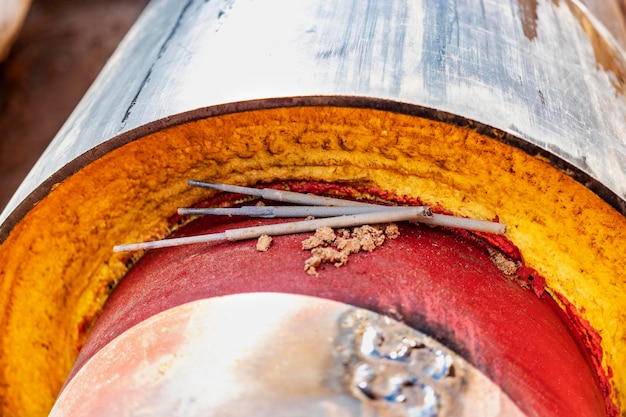 Tubo isolato Tubi metallici di grandi dimensioni con guaina in plastica posati in una trincea Tubi di saldatura insieme in una fossa in un cantiere edile