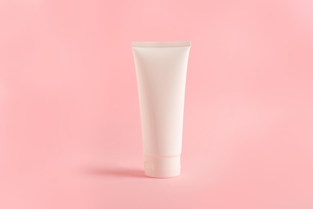 Tubo pulito con crema corpo su sfondo rosa