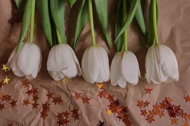 Tulipani bianchi su sfondo di carta marrone Tulipani Fiori di primavera Bouquet Foto per una cartolina