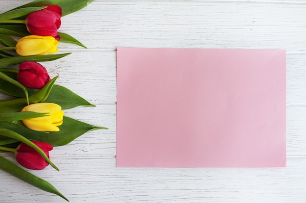 Tulipani colorati e fondo in legno bianco. Il concetto di congratu