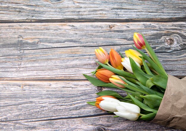 tulipani colorati luminosi su uno sfondo di legno grigio