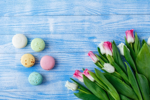 Tulipani con amaretti su fondo di legno blu. tulipani rustici.