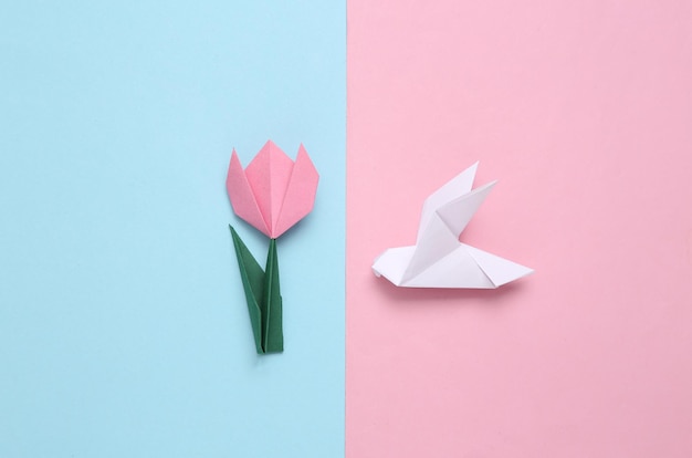 Tulipani di carta origami fatti a mano e pigeonsxAon sfondo blu rosa 8 marzo festa della mamma o concetto di Pasqua Vista dall'alto Minimalismo