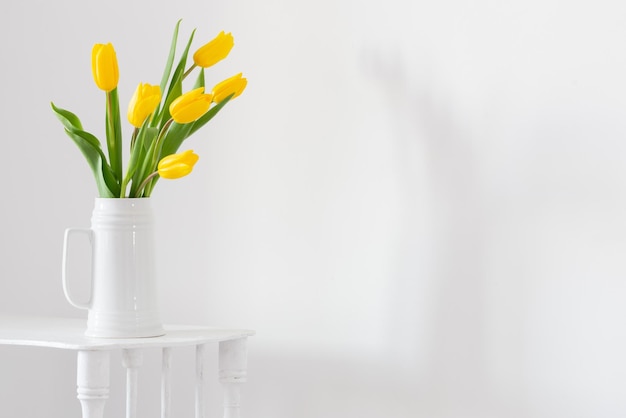 Tulipani gialli in vaso su sfondo bianco