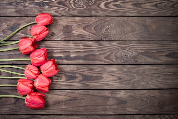 Tulipani rossi su fondo di legno scuro