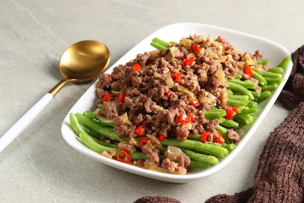 Tumis buncis daging cincang sapi o saltati in padella fagiolini o fagiolini con carne macinata.