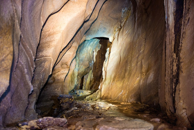 Tunnel sotterraneo all'interno di una grotta naturale scura con pareti calcaree