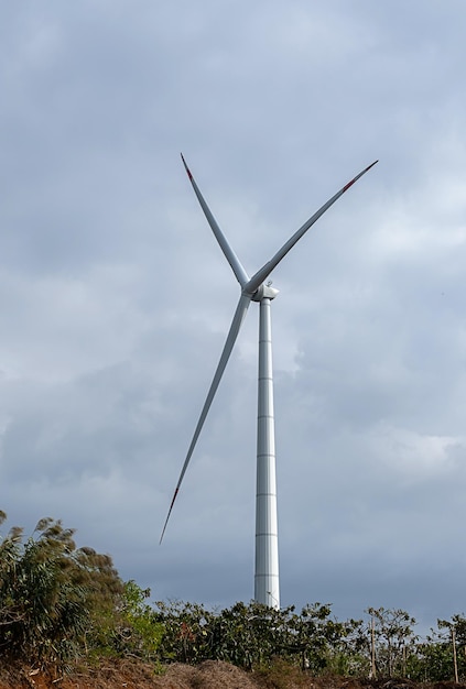 Turbina del generatore eolico contro il cielo nuvoloso blu