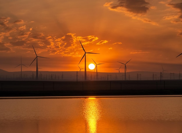 Turbine del mulino a vento all'alba con la riflessione