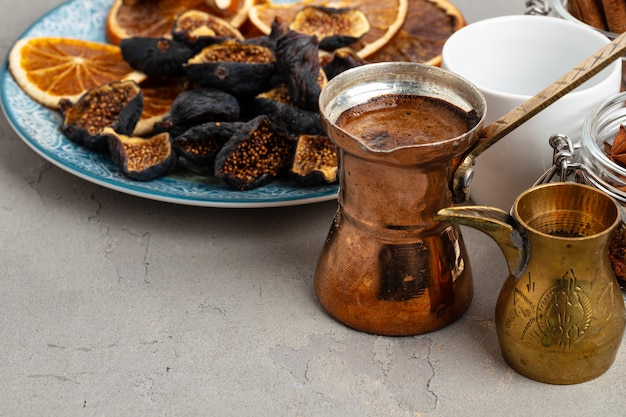 Turco di rame con i pezzi della frutta secca e del caffè sulla tavola