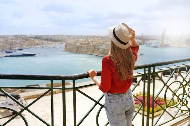 Turismo a Malta Vista posteriore di una bella ragazza che si gode la vista di tre città dai giardini Upper Barrakka La Valletta Malta