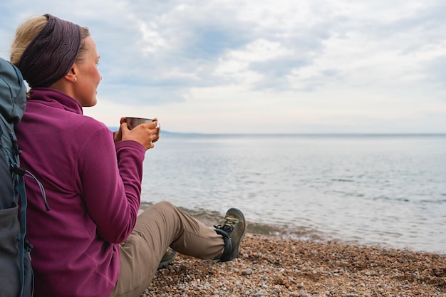 Turismo escursionistico avventura backpacker donna che si riposa dopo l'escursione guardando la bella vista escursionista ragazza