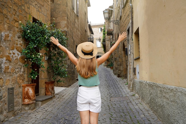Turismo in Italia Viaggia donna con braccia alzate nella storica città medievale di Orvieto Umbria Italia