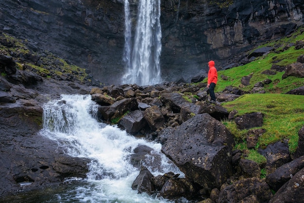 Turista alla cascata della fossa sull'isola di bordoy nelle isole faroe