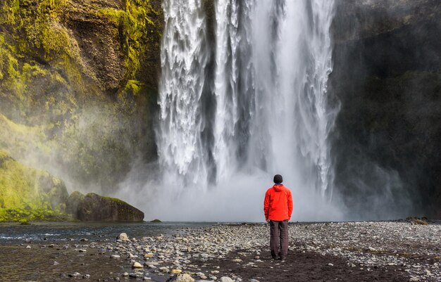 Turista alla cascata di skogafoss nell'Islanda del sud