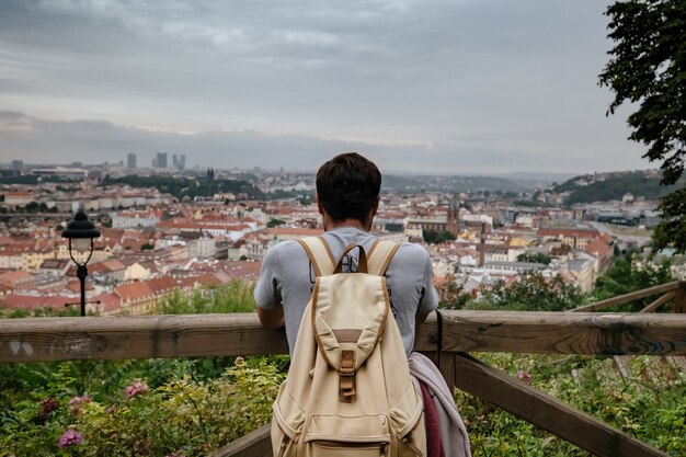 Turista alla moda felice sullo sguardo a Praga, repubblica Ceca. Bell'uomo barbuto che viaggia in Europa.